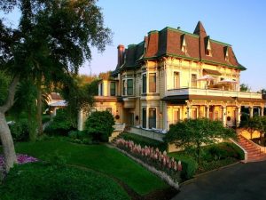 Large Victorian style home with upper balcony and grand entrance