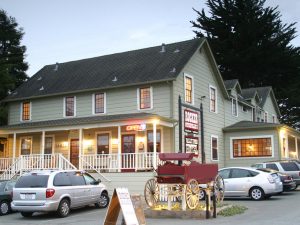 Exterior of small town hotel with buggy wagon on display in parking lot