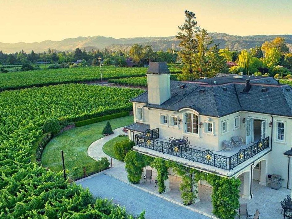 multi-story mansion with upper terrace surrounds panoramic views of vineyard