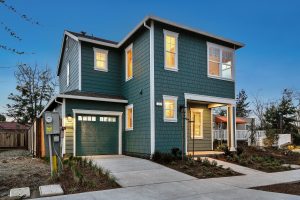 teal wooden home with shingles at dusk