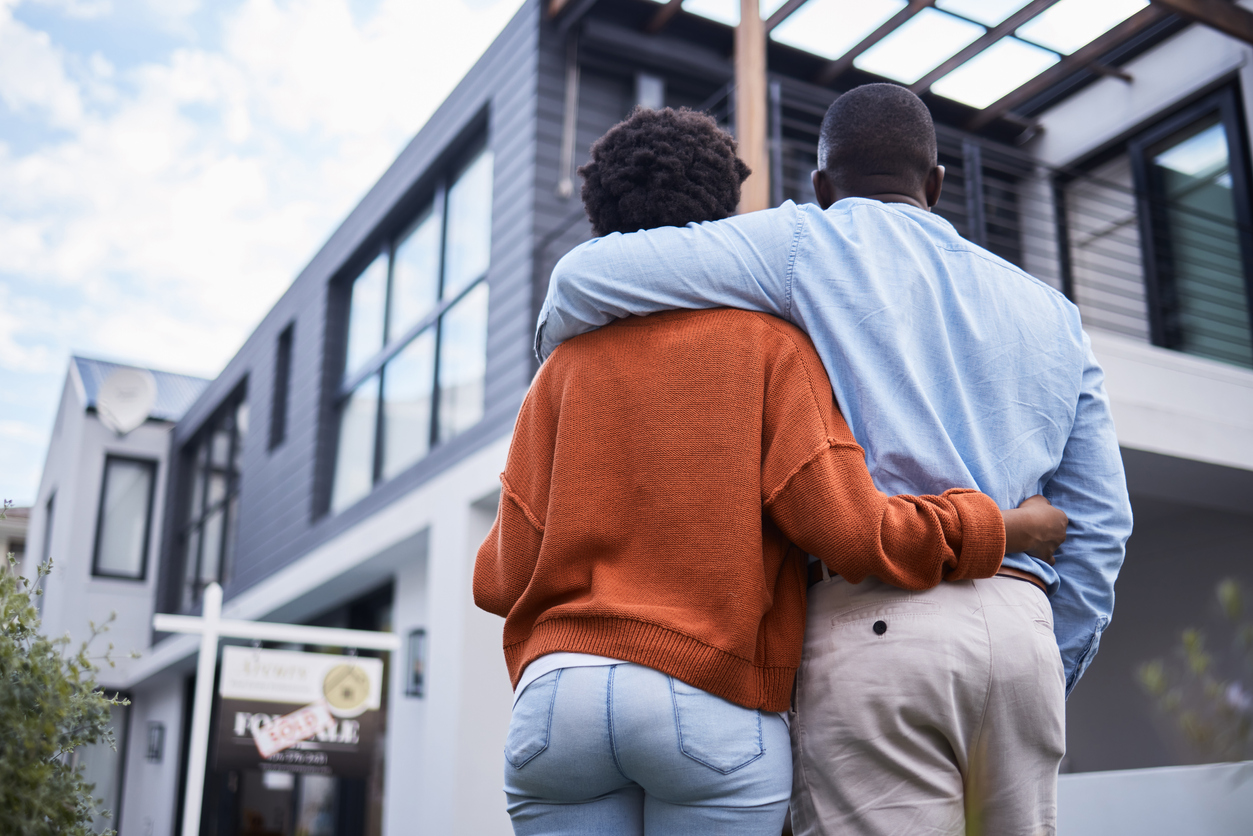 building your generational wealth through home ownership concept; black american couple looking up to new home