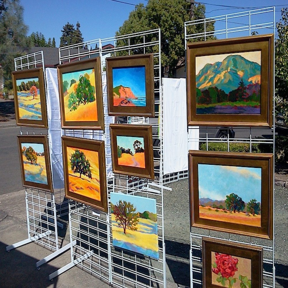 Art is hung outside in display stands for viewers to appreciate.