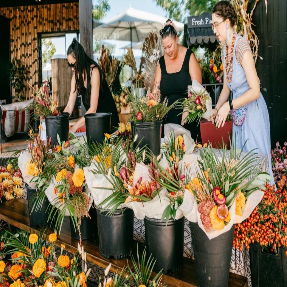 Women select from flowers placed in buckets